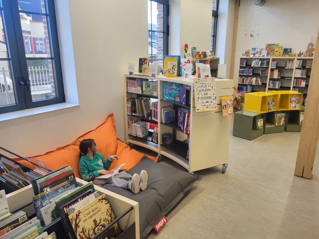 Coin lecture confortable et rayonnages jeunesse de la médiathèque Le Crotoy